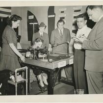 Edna Sachs sewing at the 1943 Joseph & Feiss Co. telenews display